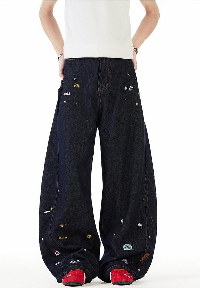 A person wearing a white shirt and black jeans with various colorful designs and patterns on them.