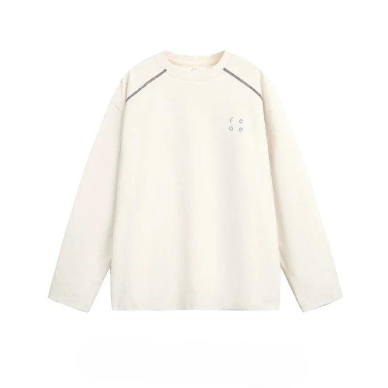 A cream-colored long-sleeved shirt with a small logo on the left side.