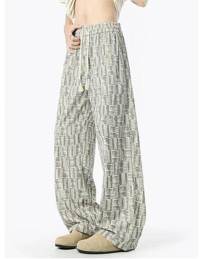 A person wearing wide-leg pants with a patterned design.